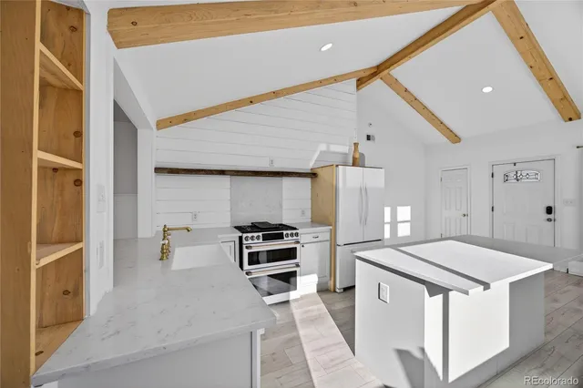 a kitchen that has a sink a stove and a refrigerator