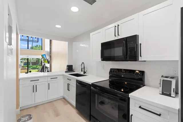 a kitchen with a sink stove and microwave