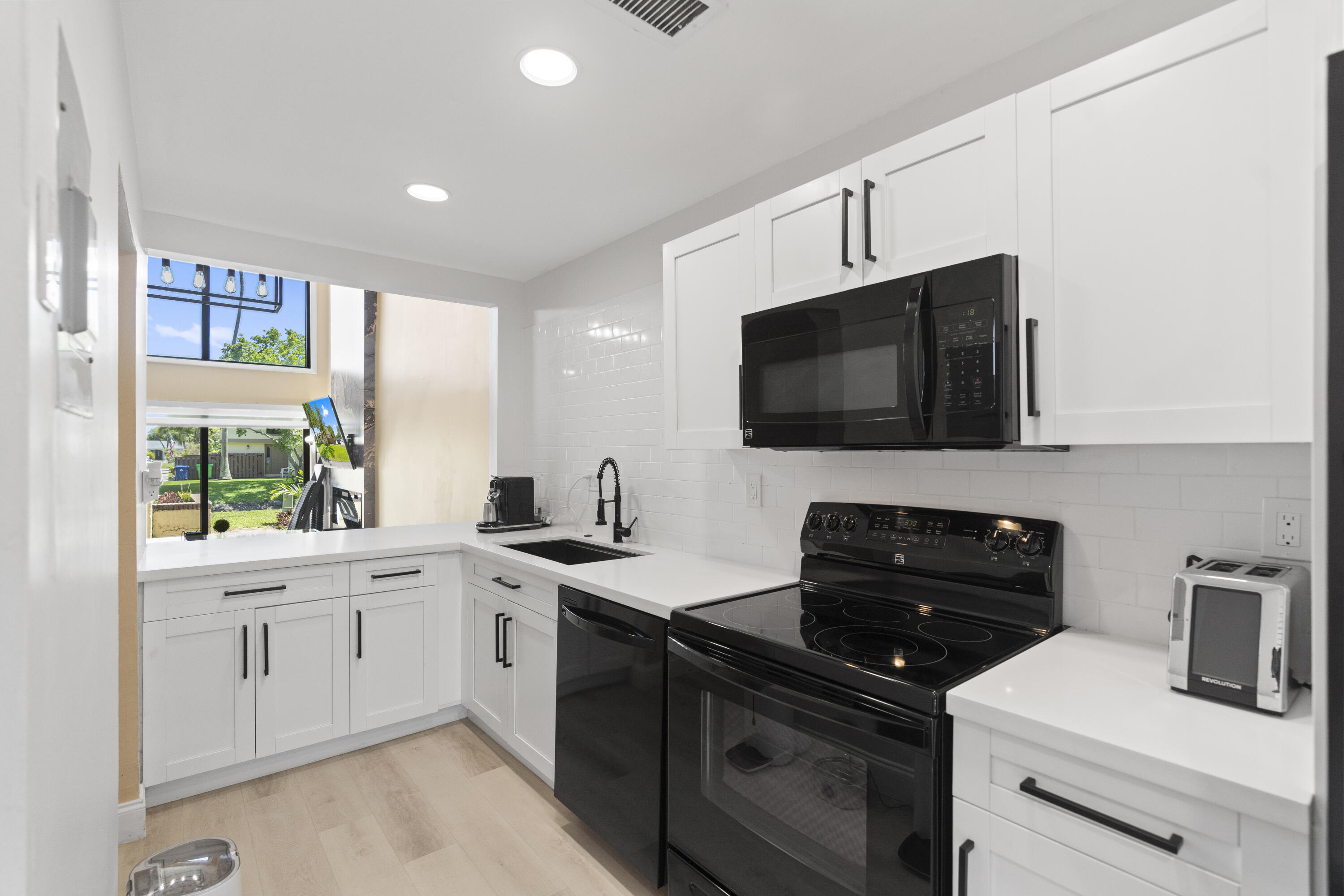 10650 Northwest 30th Place, Unit 1 Sunrise, FL 33322 - Photo 11 of 38 a kitchen with a sink stove and microwave