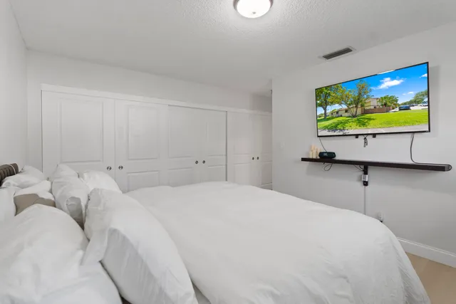 a bedroom with a bed and flat screen tv
