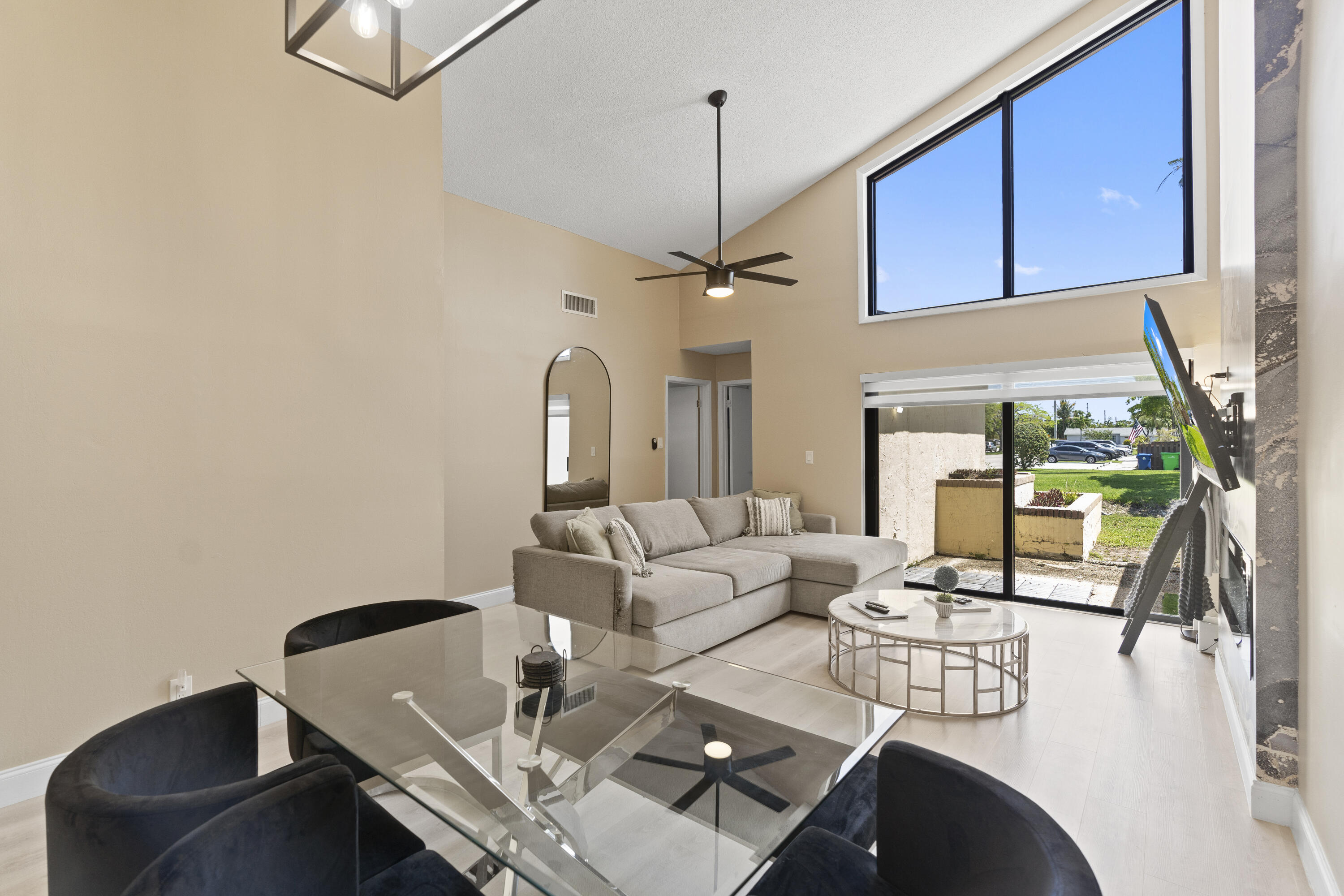 10650 Northwest 30th Place, Unit 1 Sunrise, FL 33322 - Photo 25 of 38 a living room with couches a fireplace and a dining table with garden view