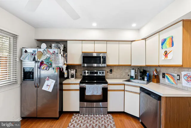 a kitchen with stainless steel appliances a stove a sink and a refrigerator
