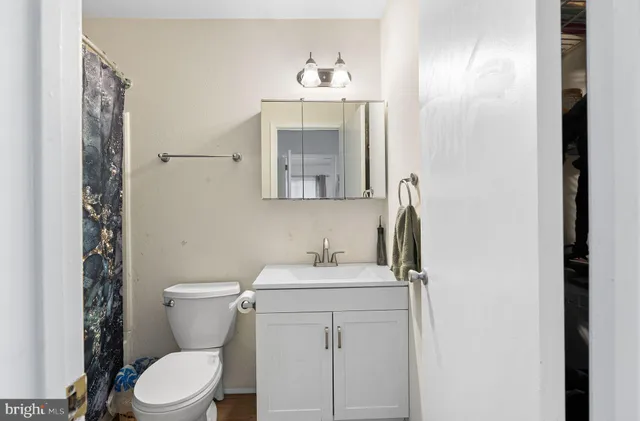 a bathroom with a sink mirror and toilet