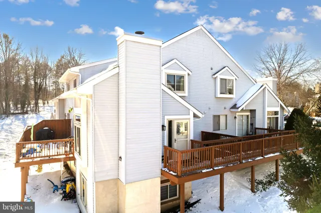 a view of a white house next to a yard