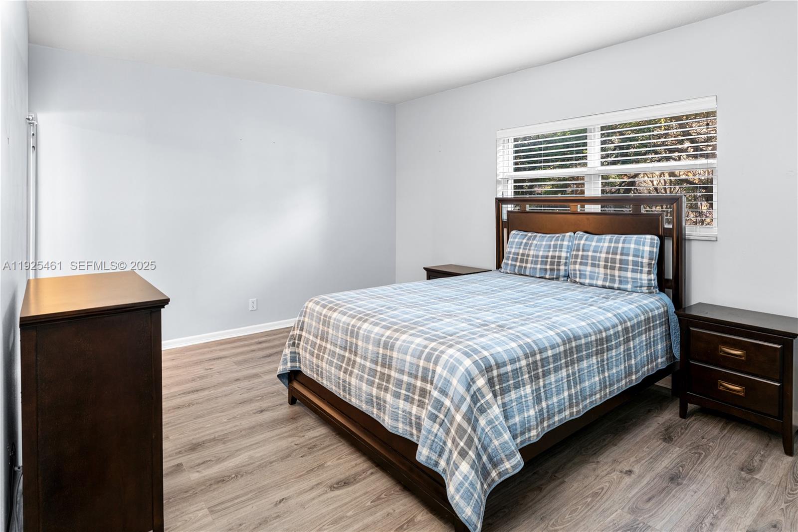 6751 Cypress Road, Unit 207 Plantation, FL 33317 - Photo 6 of 20 a bedroom with a bed and wooden floor