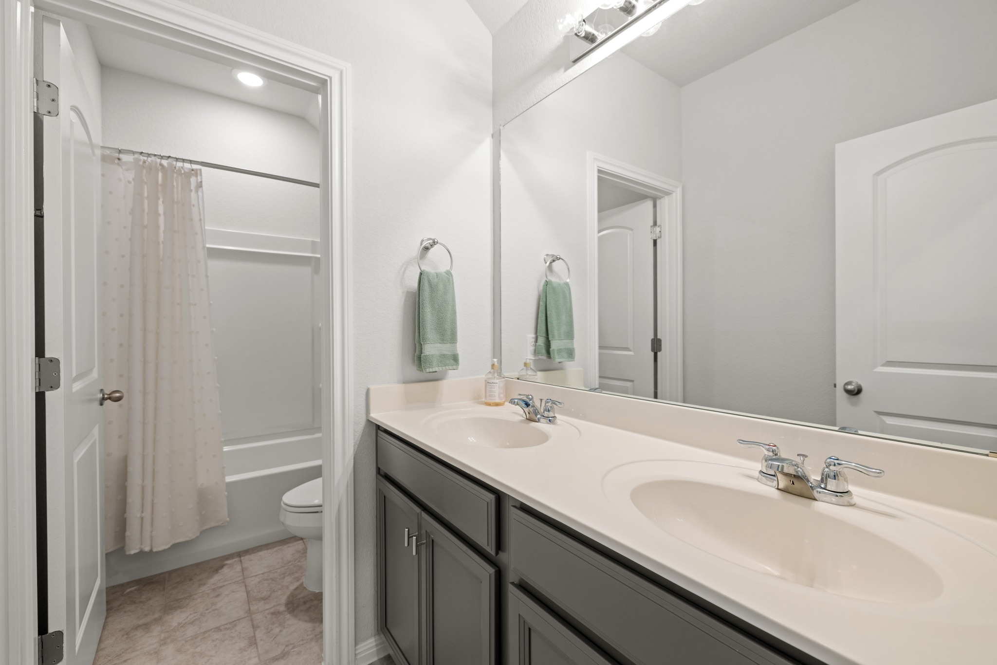 2049 Winston Way Leander, TX 78641 - Photo 18 of 35 Secondary hall bathroom with dual vanities and ceramic tile flooring.