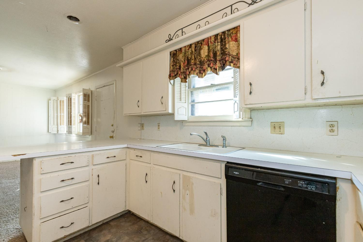 3621 56th Street Lubbock, TX 79413 - Photo 14 of 32 a kitchen with cabinets appliances a sink and a window