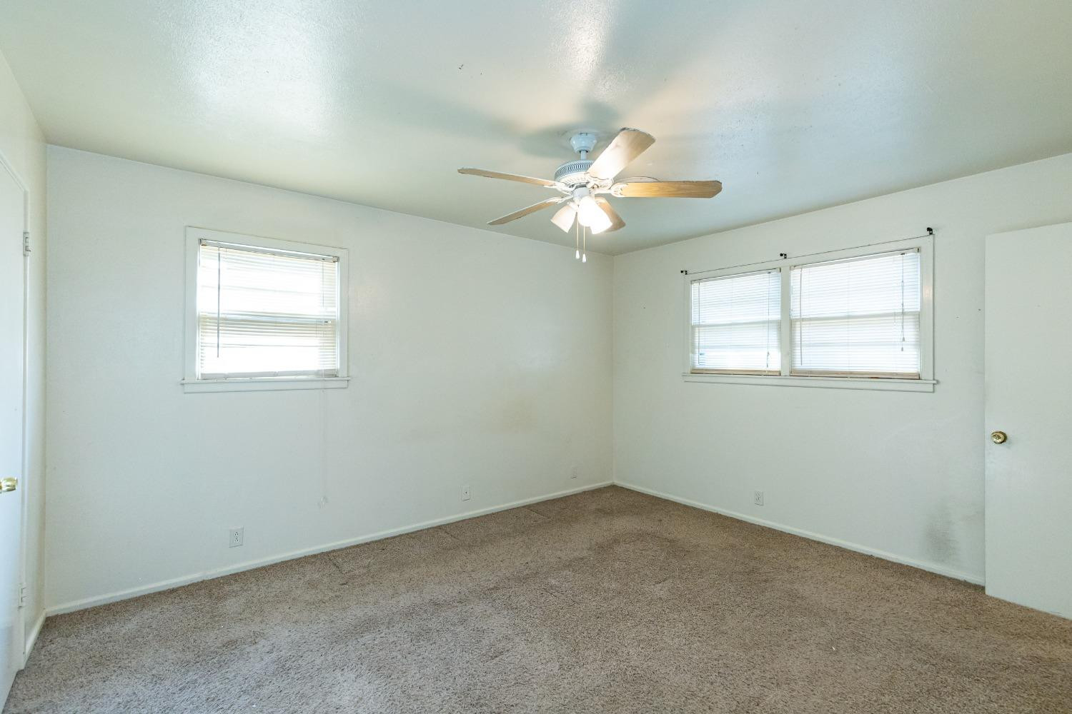 3621 56th Street Lubbock, TX 79413 - Photo 16 of 32 an empty room with windows and ceiling fan