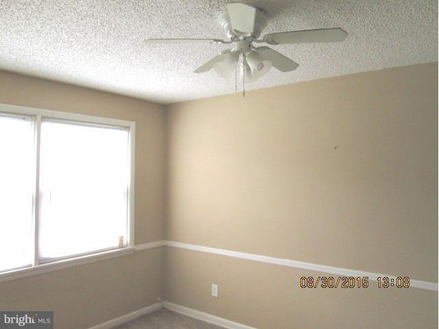 1233 Silverthorne Road Baltimore, MD 21239 - Photo 3 of 13 an empty room with a window and a fan
