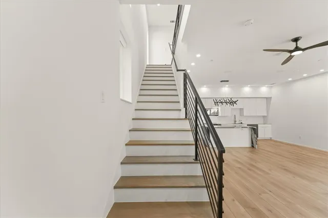 a view of a hallway with wooden floor and staircase