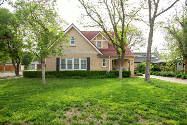 a front view of a house with a yard and trees