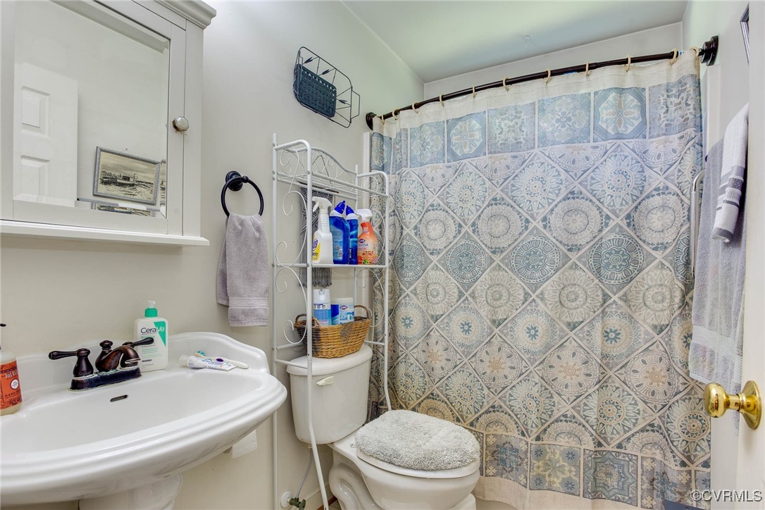 3875 Wakema Road West Point, VA 23181 - Photo 27 of 45 a bathroom with a sink a toilet and shower curtain