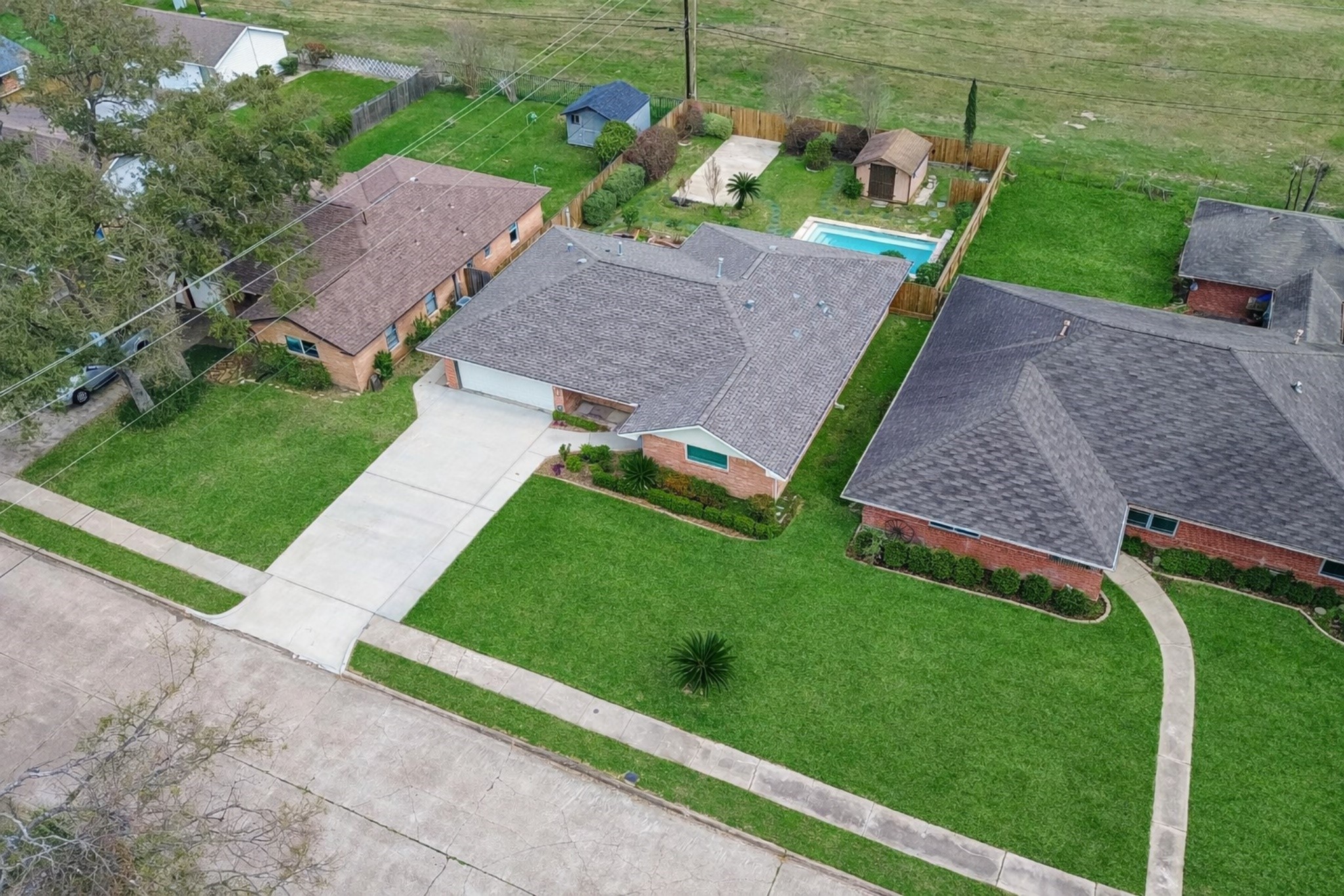 Welcome to 1506 Foxwood Road!  This aerial view reveals a spacious front and backyard with a glistening pool, fully fenced, and extremely private!
