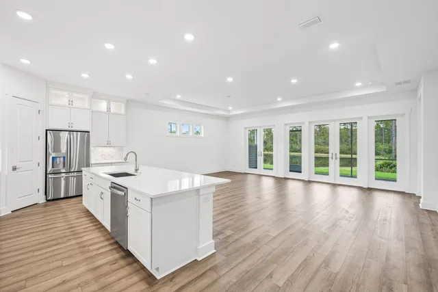 a large kitchen with stainless steel appliances granite countertop a large counter top and a wooden floors
