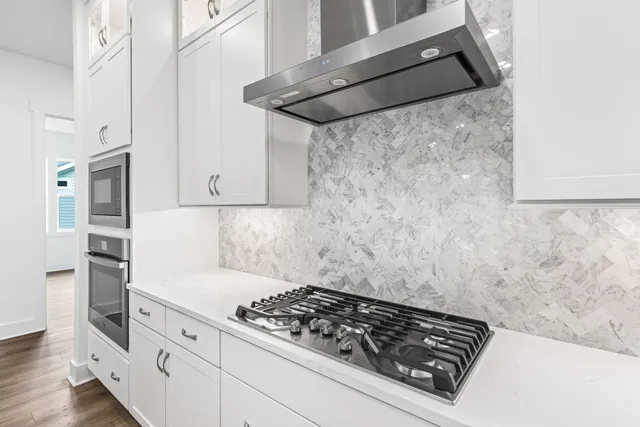 a kitchen with white cabinets and appliances