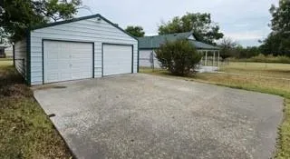 a view of a house with backyard and trees