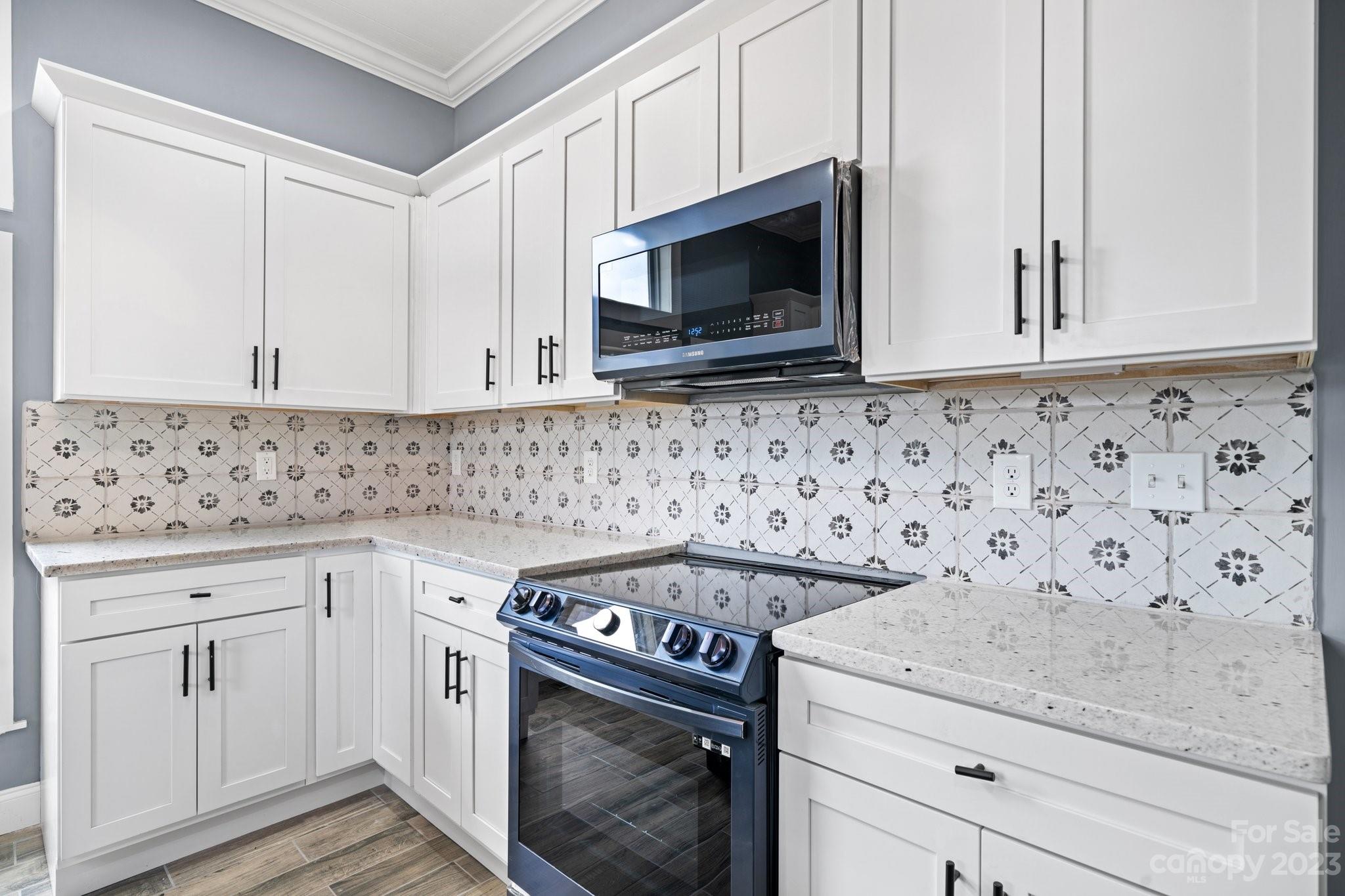 403 2nd Street Southeast Conover, NC 28613 - Photo 6 of 35 a kitchen with granite countertop white cabinets and stainless steel appliances