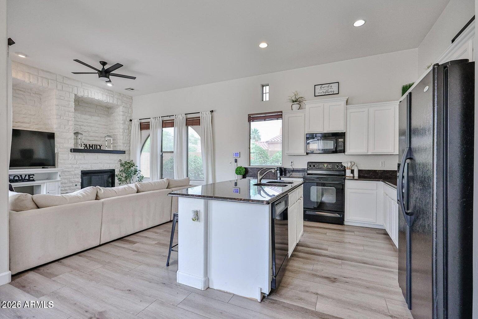 3950 North Edith Way Buckeye, AZ 85396 - Photo 13 of 32 a kitchen with white cabinets and stainless steel appliances