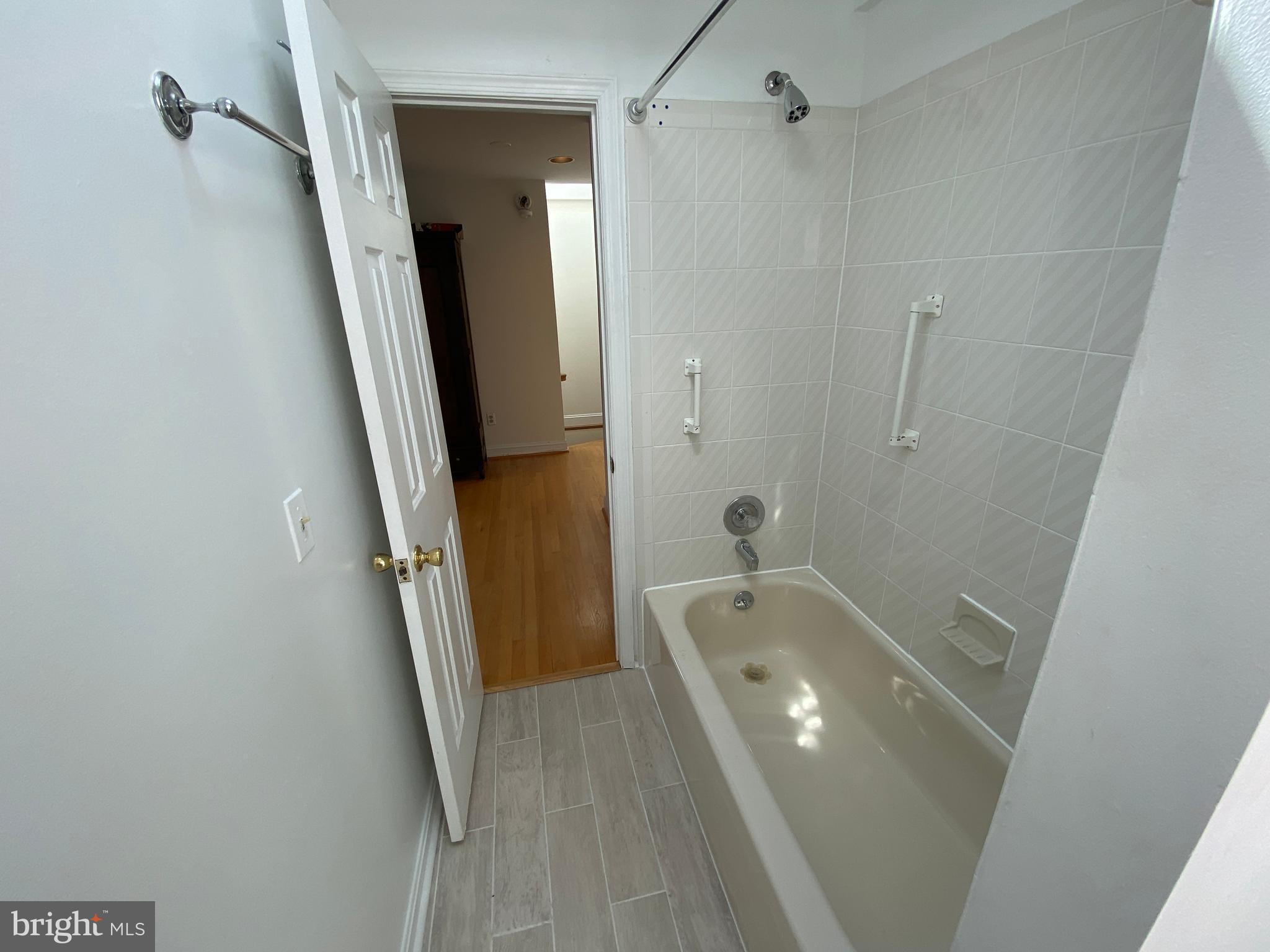 600 Acker Place Northeast Washington, DC 20002 - Photo 13 of 17 a bathroom with a tub a sink and a large mirror
