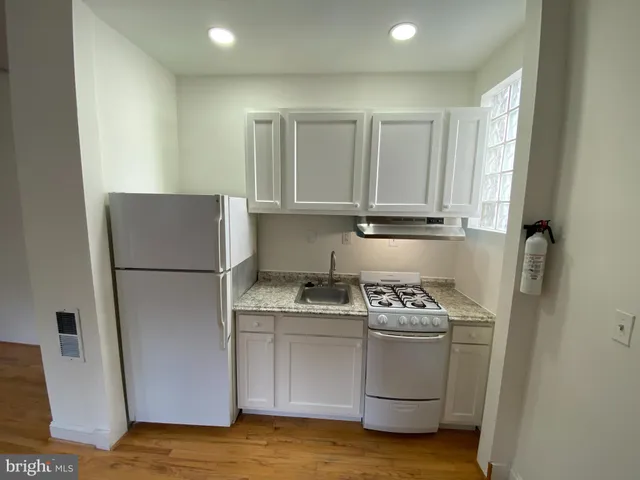 a kitchen with a refrigerator a stove a sink and cabinets