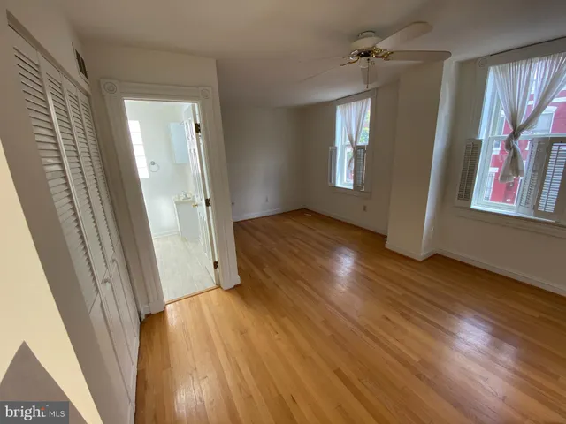 an empty room with wooden floor and a window