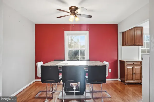 a room with stainless steel appliances kitchen island granite countertop a stove a refrigerator and a dining table with wooden floor