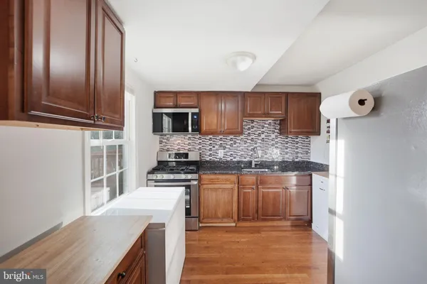 a kitchen with stainless steel appliances granite countertop a stove and a refrigerator