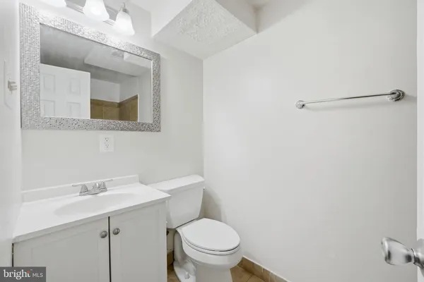 a bathroom with a sink a toilet and a mirror
