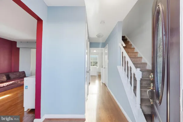 a view of a hallway with wooden floor and staircase