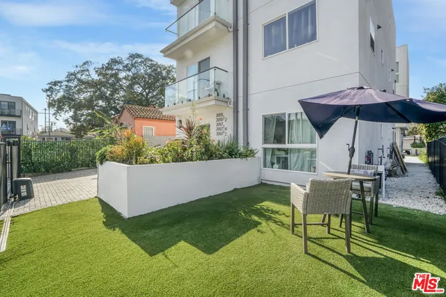 a view of a patio with table and chairs under an umbrella