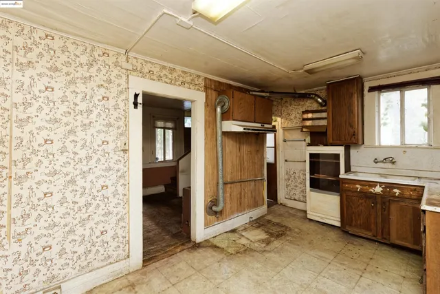 a view of a kitchen with refrigerator and a sink