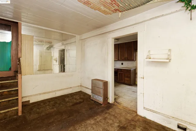 a view of a livingroom with wooden floor and kitchen space