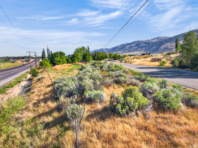 4380 Main Street Logan, UT 84321 - Photo 66 of 74 Expansive undeveloped land featuring natural vegetation, a paved roadway, and a distant mountain range