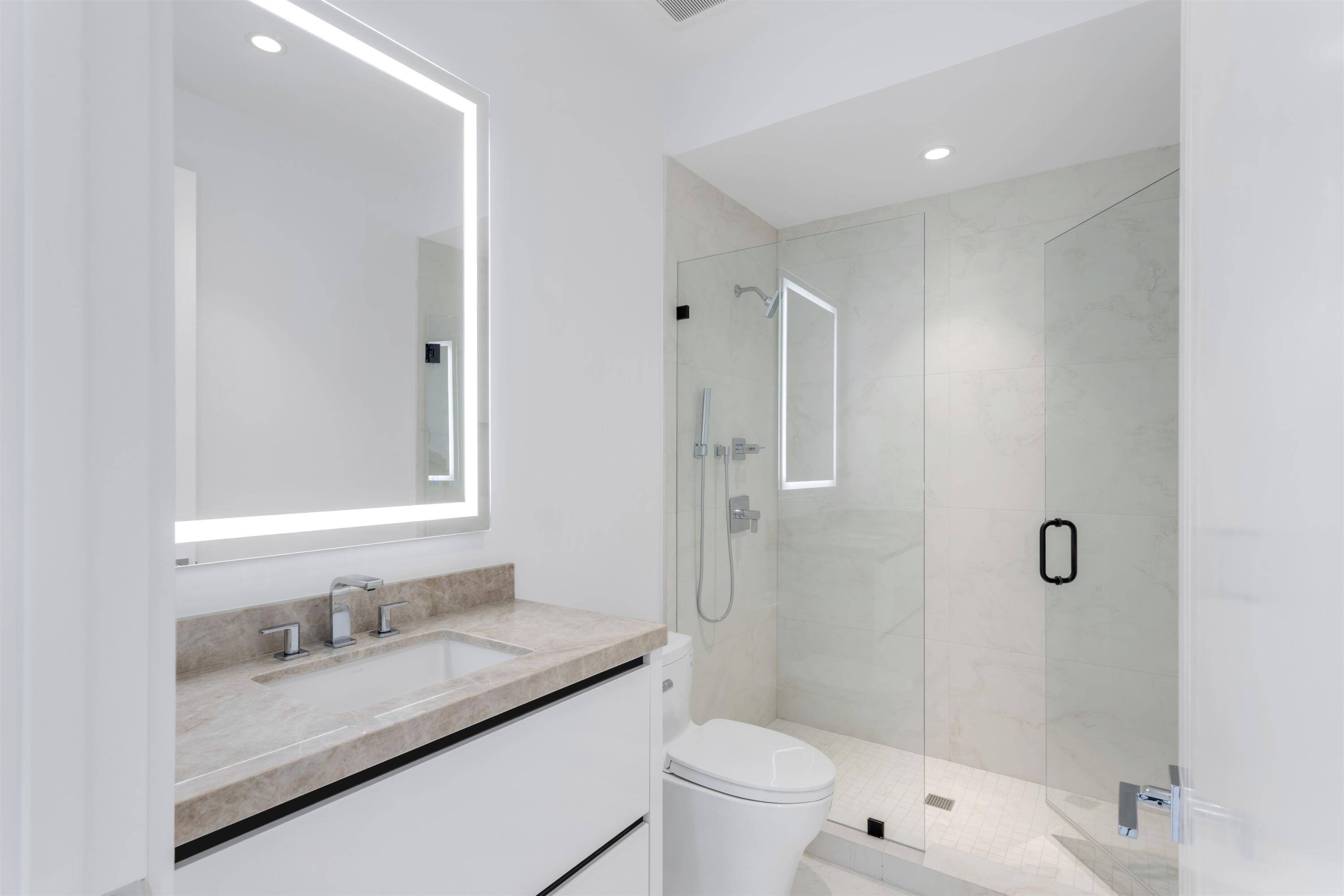 900 Lago Mar Lane, Unit PH Boca Raton, FL 33431 - Photo 29 of 58 a bathroom with a granite countertop sink a toilet and shower