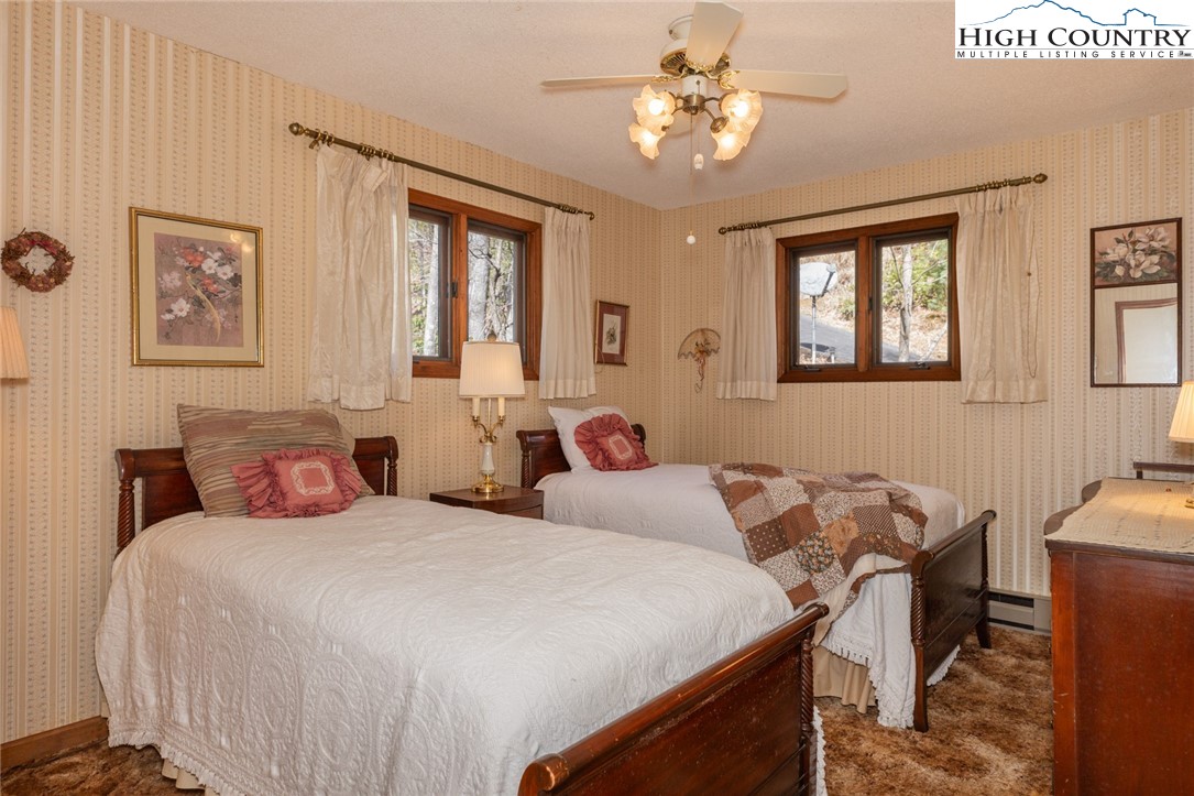 184 Birch Lane Deep Gap, NC 28618 - Photo 11 of 31 a bedroom with a bed and a chandelier