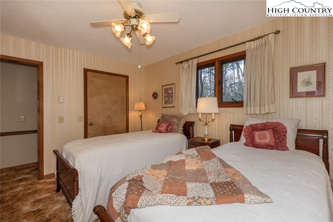 184 Birch Lane Deep Gap, NC 28618 - Photo 12 of 31 a bedroom with a large bed and a chandelier