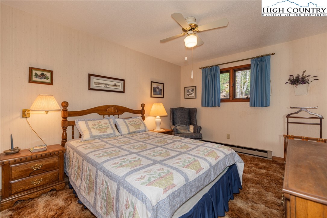 184 Birch Lane Deep Gap, NC 28618 - Photo 14 of 31 a bedroom with a bed a chandelier and a dresser