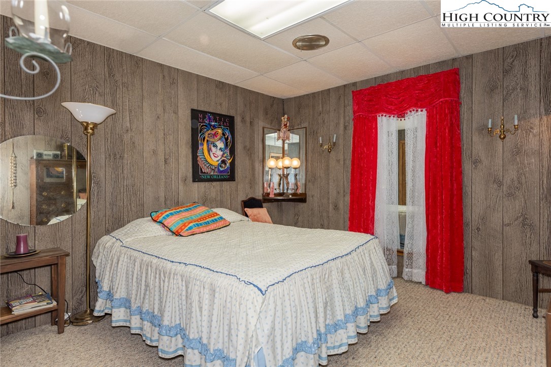 184 Birch Lane Deep Gap, NC 28618 - Photo 23 of 31 a bedroom with a bed and a chandelier