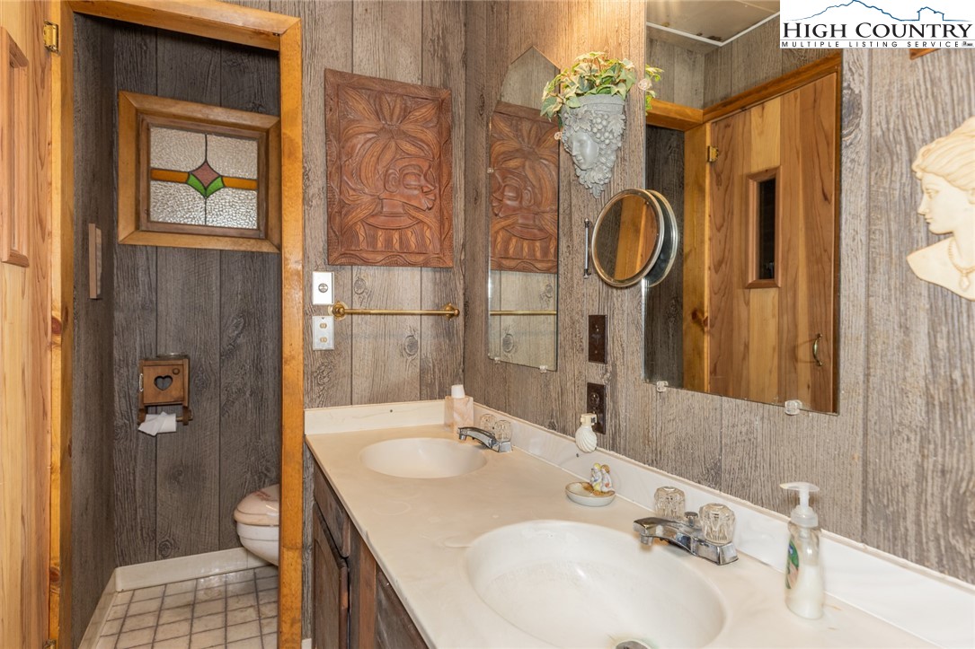 184 Birch Lane Deep Gap, NC 28618 - Photo 25 of 31 a bathroom with a granite countertop sink a mirror and a shower