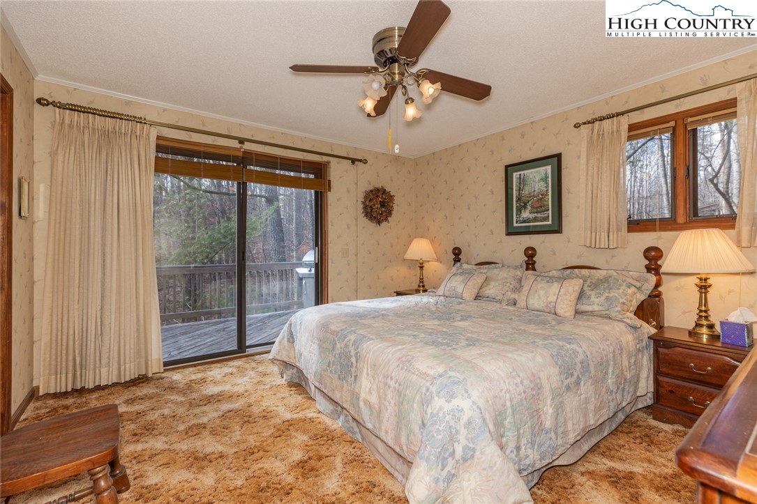 184 Birch Lane Deep Gap, NC 28618 - Photo 9 of 31 a bedroom with a large bed and a lamp