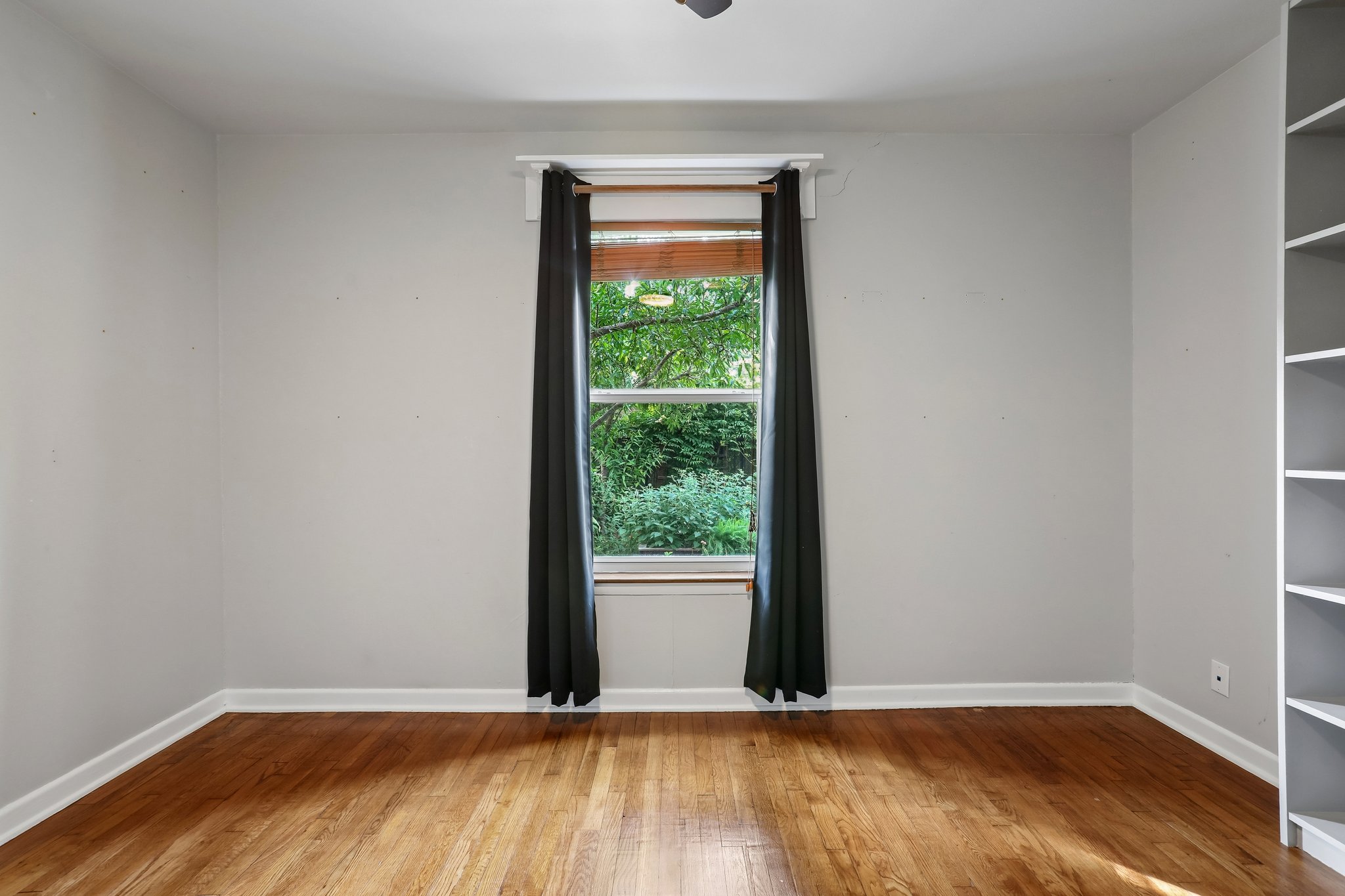 1114 West 2nd Street Elgin, TX 78621 - Photo 13 of 31 Sun-filled room boasts polished hardwood flooring and serene outdoor green views.