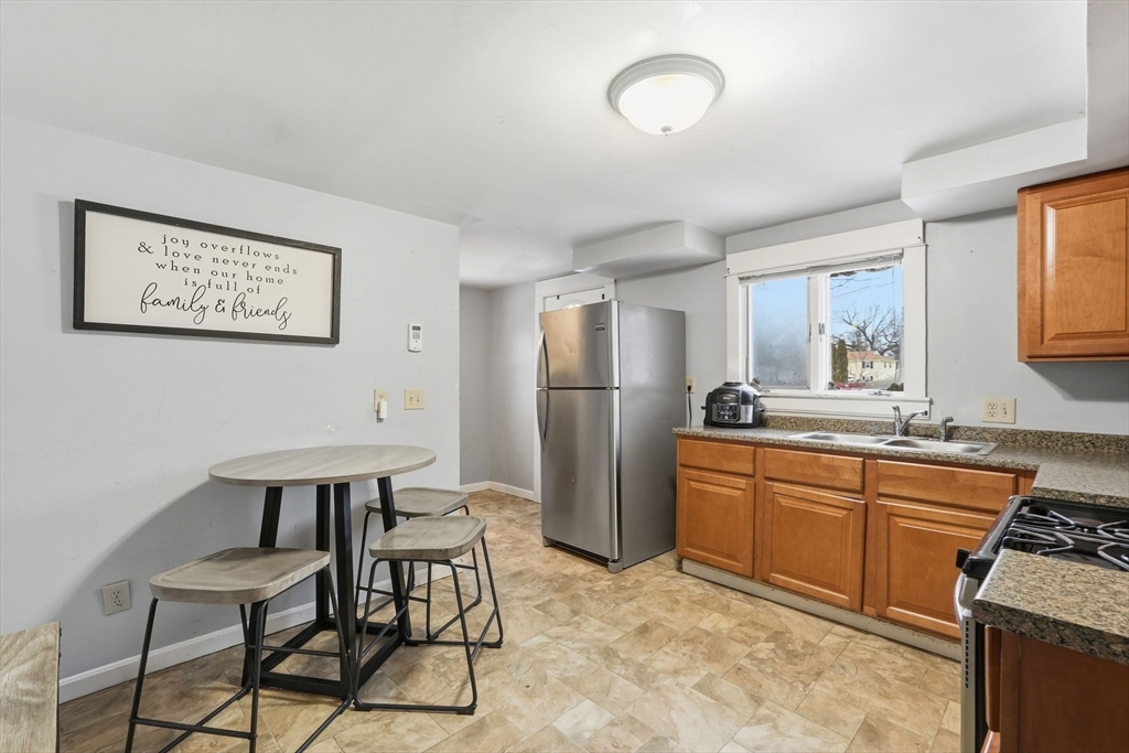 a kitchen with stainless steel appliances granite countertop a sink and a refrigerator