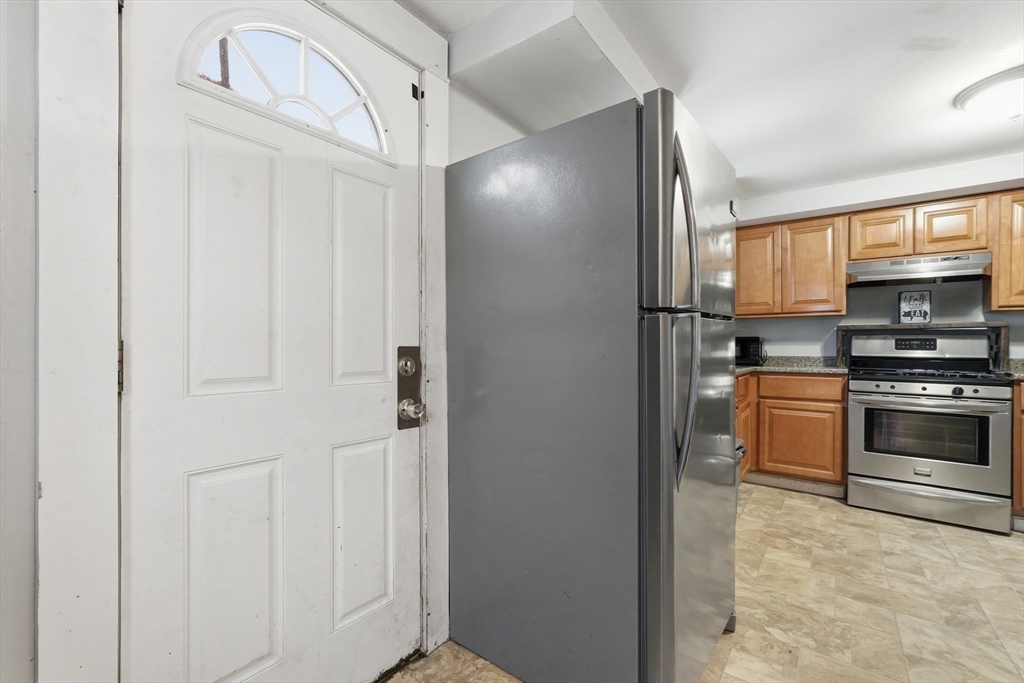 34 Savoy Avenue Springfield, MA 01104 - Photo 3 of 35 a kitchen with granite countertop a refrigerator and a stove top oven