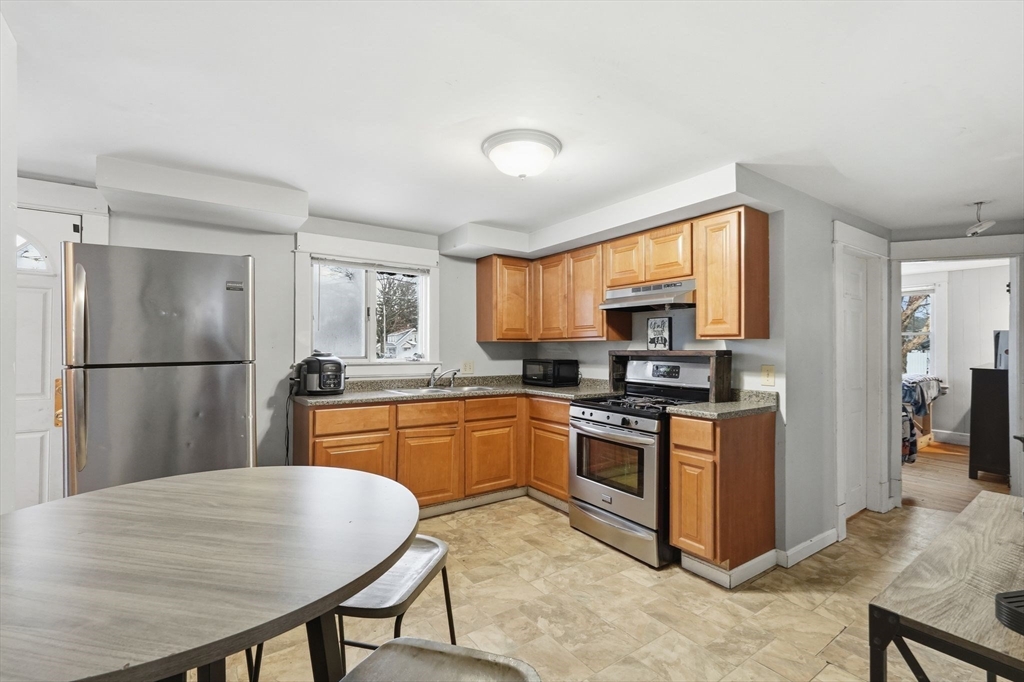34 Savoy Avenue Springfield, MA 01104 - Photo 4 of 35 a kitchen with stainless steel appliances granite countertop a refrigerator a stove top oven a sink dishwasher and wooden cabinets