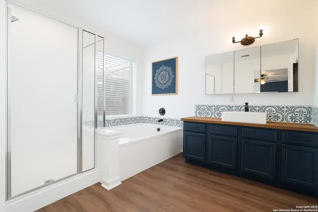 a spacious bathroom with a tub double sink and mirror