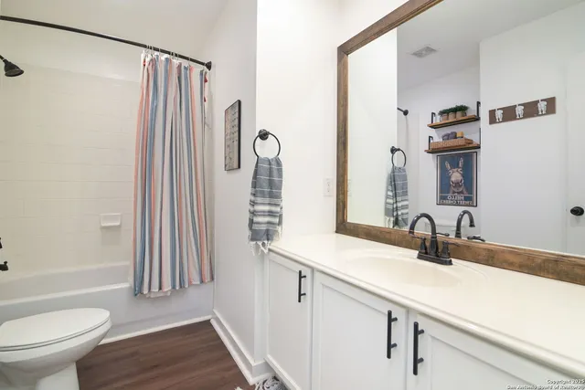 a bathroom with a sink a toilet and a mirror
