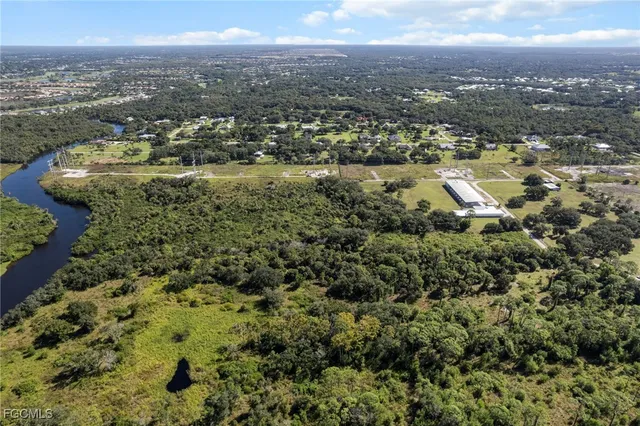 an aerial view of residential houses with outdoor space and trees