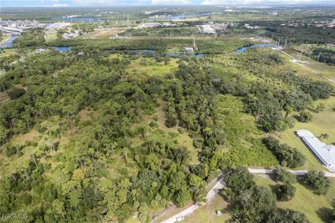 an aerial view of residential houses with outdoor space and trees