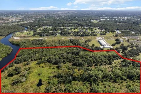 an aerial view of residential houses with outdoor space and trees