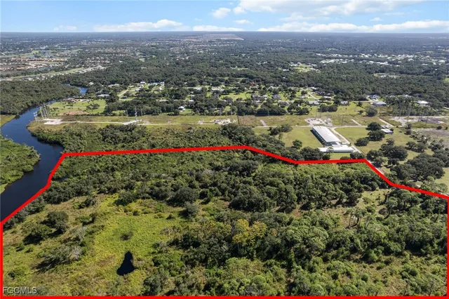 an aerial view of residential houses with outdoor space and trees